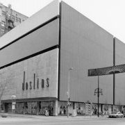 View of Joslins Department Store at the corner of Curtis Street and the 16th (Sixteenth) Street Mall in downtown Denver, Colorado. The building has a stone and concrete facade with show windows at street level.