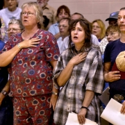 Residents say the pledge of allegiance at a community briefing.