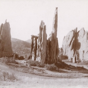 View of Cathedral Spires, a sandstone rock formation at Garden of the Gods near Colorado Springs (El Paso County), Colorado. Shows a dirt road and brush.