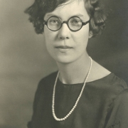 Anna Berggren poses for her South High School senior portrait in Denver, Colorado. Berggren's hair is styled in a wavy bob and she wears round eye glasses.
