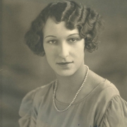 Dorothy Adler poses for her South High School senior portrait in Denver, Colorado. Adler's hair is styled in a wavy bob and she wears a blouse with sheer gathered sleeves, and a pearl necklace.
