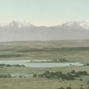 Panoramic view of unidentified lakes or ponds, a plain scattered with trees, and the Spanish Peaks in Huerfano County, Colorado.