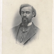 Studio portrait of probably Frederick Douglass, Jr., writer, abolitionist, activist and son of abolitionist, Frederick Douglass. He wears a celluloid collar, tie, vest and jacket. His hair is parted to the side. He has a Van Dyke beard and mustache.