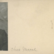Studio portrait of possibly Charles Moore, a railroad employee (stationing engineer) and resident of Black hawk, Colorado. He poses in front of a painted backdrop. He wears a dark suit and vest and a bow tie. His dark hair is parted on the side and he has a long, bushy mustache.