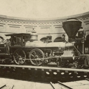 View of a locomotive, "The General," Western and Atlantic Railroad engine no. 3 on a turntable in a roundhouse probably in Atlanta, Georgia. The tender is full of wood. A man stands on the locomotive and holds an oil can.