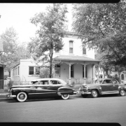 The Negro Woman's Club Association and George Washington Carver Day Nursery Building at 2357 Clarkson Street is featured from Clarkson street. Cars are parked out front.