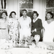 Five women identified as George Washington Carver staff stand behind a table featuring punch bowls and tea snacks. The women are identified on the verso as "Staff at Nursery," and (L-R) "Baily, Ford, Boggess, Brown, and Edwards." The woman identified as "Ford" is believed to be long-time Carver teacher and director Erma Ford, who served at the school for more than 30 years.