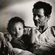 Millete Brehane Meskele, 2, relaxes with her father, Brehane Meskele Madhaiy in their new home. They immigrated from Ethiopia. 