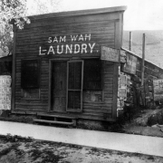 Facade of the Sam Wah Chinese Laundry, Colorado Avenue, Colorado City, (capitol of Colorado Territory in 1861) El Paso County, Colorado; shows a clapboard false front. Signs read: "Dixie Queen," "Old Virgin," and "Sam Wah L-aundry."