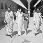 Four Indian women walk through Union Station in Denver, Colorado. Three of the women wear saris and one is dressed in a dress and hat.