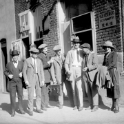 A group of men, a Chinese man, and a woman stand near a brick building on Market Street in Denver, Colorado. A nearby sign reads: "Yee Lee &amp; Co 2029 Market St." Chinese characters are also on the sign.