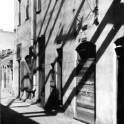 View of a building on Hop Alley in Denver, Colorado. The two-story building has a small metal gate over one of the doorways.