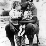 A Hispanic women holds a young girl in Colorado. The woman also holds a doll.