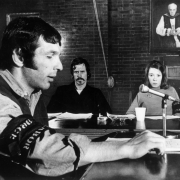 Jonathan "Skip" Chase gives a speech at a press conference during a hunger strike staged by Migrants in Action to protest the living conditions of migrant workers near Fort Lupton (Weld County), Colorado. Tomm Hewes and Miss Fey Falcon sit nearby.