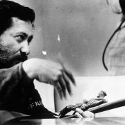 Lalo Delgado discusses Weld County migrant workers' living conditions in Colorado. He holds a crucifix.