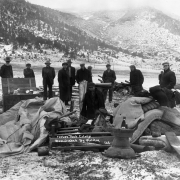 Men and boys (including Japanese) stand in the snow at the UMW camp for coal miners on strike against CF&amp;I in Forbes, Las Animas County, Colorado; mattresses, clothes, and household items are in a pile.