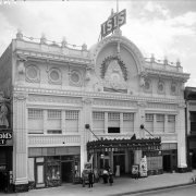 View of the Isis Theater at 1722 Curtis Street in downtown Denver, Colorado. The three-story building has an ornate facade and marquee. Signs on buildings read: "Dr. Murphy's Root Beer," "The West Cigar," "Vitagraph," and "The Nanking Chinese Chop [Suey]."