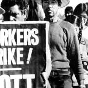 Shows United Farm Workers of America Union members as they walk down a road, possibly in Colorado, in support of California farm workers on strike. They called for a boycott of grapes and of Safeway Incorporated.