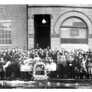 A black and white photograph taken outside the Buddhist Church in the 1930's.  The casket is in the center of the photograph surround by those attending the funeral service.