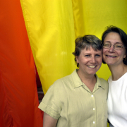 Bridget Brophy and wife Suzanne Banning, both from Denver, pose in front of a gay pride flag at Civic Center Park during PrideFest (CQ. PrideFest) Sunday June 27, 2004 in Denver.