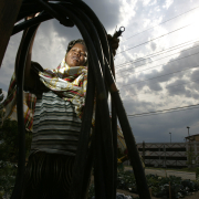 Somali Bantu refugee Halima Abdi, cq, 23, winds a hose at her plot in the Fairview Garden at Decatur St. and 12th in Denver Thursday July 21, 2005. 