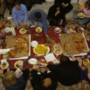 After voting in the Iraqi election, Ahmad Dizayee, bottom center, celebrates at a post-election feast at the home of Kurdish friends in San Diego. Dizayee traveled from Lakewood to Irvine, Calif., to vote Saturday. The California polling place was the only one west of the Mississippi River.