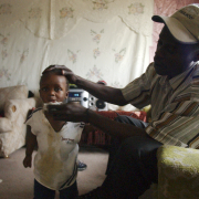 Somali refugee Ubed Hussein wipes the mouth of his 2-year-old child, Abdirahman, after lunch. Hussein is worried about the rent increase his family will face in July. He has a job at Denver International Airport, but he doesn&apos;t earn enough to cover the rent increase and food for his family of four.