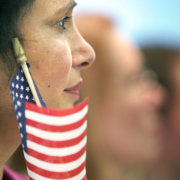 Woman holds American flag next to face