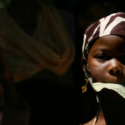 11 year-old Shafera Guhed holds a dollar in her mouth as part of a traditional Somali Bantu dance on Washington Park in  Denver, on July 1st, 2007. 