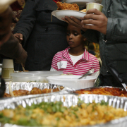 LaLa Ali, 6, a refugee from Somalia looks over dishes as she makes her way down the food line with her mother Faduma during the Refugees' First Thanksgiving event at the African Community Center in Denver Tuesday Nov. 25, 2008.