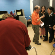 Scott Robbins (orange shirt), of Mercy Housing explains voting to a group of Burmese refugees at the voting center at Montclair Recreation Center in Denver, Colo., on Friday, Oct. 31, 2008. 