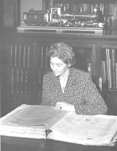 Agnes reads bound volume of Rocky Mountain News at Denver Public Library