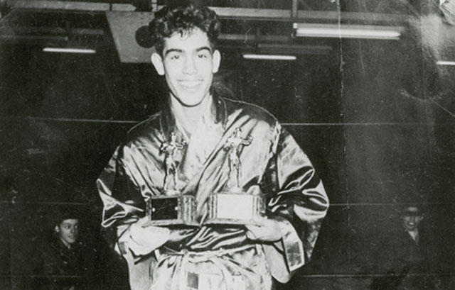 Rodolfo "Corky" Gonzales holding his Diamond Gloves and Golden Gloves trophies that he won