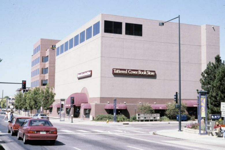 View of the Tattered Cover Bookstore at 2955 East 1st (First) Avenue in the Cherry Creek Neighborhood of Denver, Colorado. The five-story brick building was constructed in 1995. The building has dark rectangular windows on the fifth story.  It is painted a dark red color on the first floor.  The first floor has awnings over the windows and doors. Shows the intersection of 1st Avenue and East Milwaukee Street.
