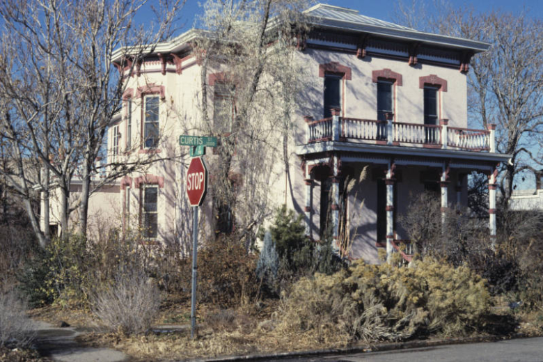 View of the Mannat House (c. 1881) at 2905 Curtis Street in the Five Points neighborhood of Denver, Colorado. This two-story Italianate residence is part of the Curtis Park-Champa Street Historic District. Built for Irving Mannat, a grocer, this brick house has a symmetrical facade, truncated hipped roof, bracketed cornice, lintels, a covered porch, a balustrade and bays.