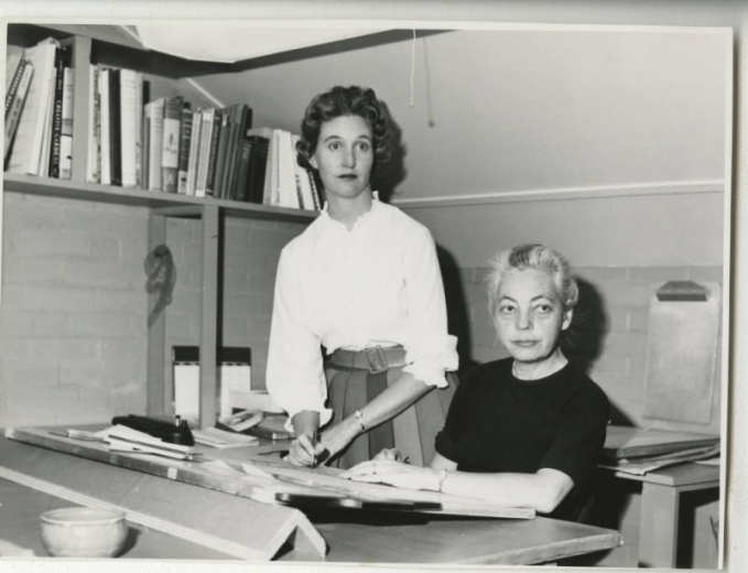 Informal black and white photograph of Jane Silverstein Reis with an employee taken in her office at 737 Franklin Street, Denver, Colorado.