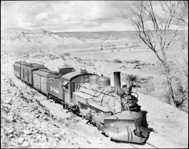 Rio Grande Train 452 (Denver and Rio Grande Western Railroad); engine 475 (Schenectady type 2-8-2) Chili Line, Santa Fe Branch; shows two freight and one passenger car near Santa Fe, Santa Fe County, New Mexico.