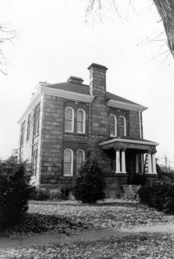 View of a house at 2501 High Street in the Whittier neighborhood of Denver, Colorado. The two-story brick house has arched windows, covered entryway, and a chimney.