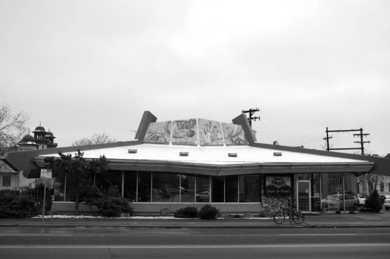 This building was built in 1967 and designed by Armet and Davis of Los Angeles in a Googie style. This was a White Spot coffee shop, one of a chain that closed in 2001. A Tom's Diner sign is visible in the photo, who have occupied the building since 1999.