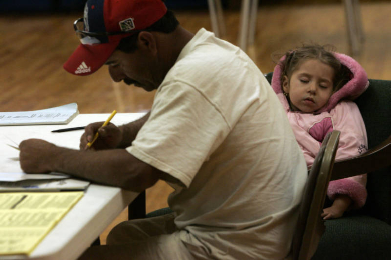 Eduardo Castillo votes while his daughter Yarelin Castillo, 3, sleeps, at the Swansea Recreation Center in  Denver, November 4, 2008. Rocky Mountain News