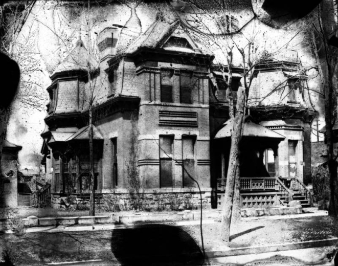 View of a house at 2601 Champa Street in the Five Points neighborhood of Denver, Colorado. The brick and stone Second Empire style house has a mansard roof, belt course, covered porch, and octagonal towers.