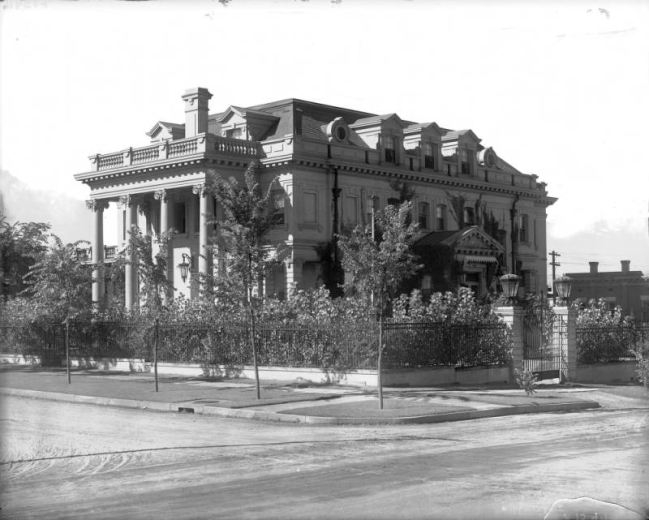 View of the Crawford Hill house at East 10th (Tenth) and Sherman Street in the Capitol Hill neighborhood of Denver, Colorado; features gables, a covered porch, a balcony, balustrades, gatepost lamps, and gables.