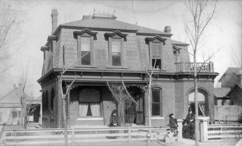 View of the George W. Kramer home at 2445 California Street in the Five Points neighborhood of Denver, Colorado; features a mansard roof, terrace, and covered porch. Women pose with a boy and a dog.