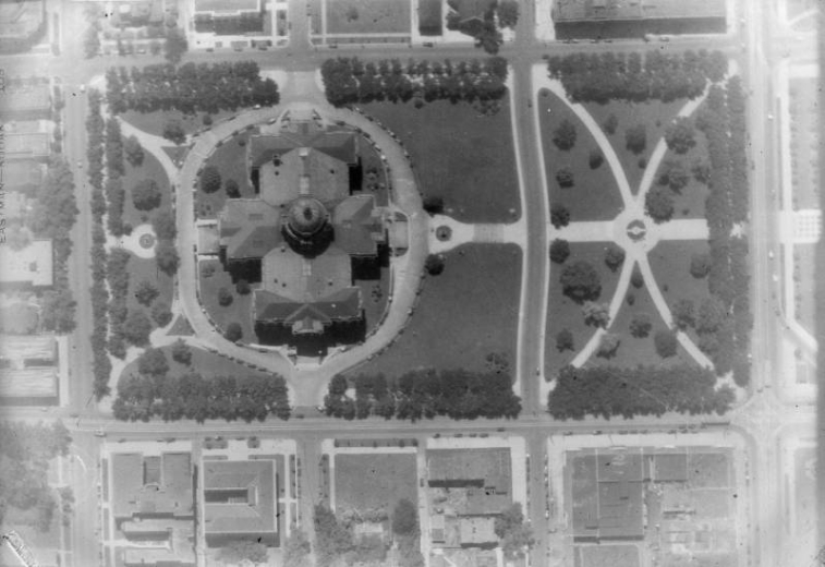 Aerial view of Denver, Colorado; shows the Colorado State Capitol building, landscaping,  streets and buildings.