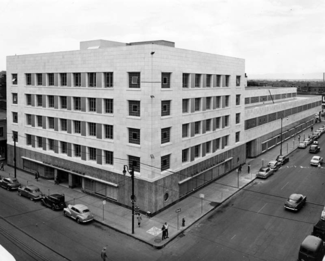 View of the Denver Post newspaper headquarters at 15th (Fifteenth) and California Streets in downtown Denver, Colorado. Cars are in the street by the Deco style entry.
