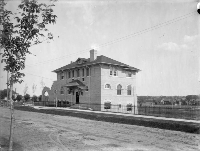 This Mediterranean Revival style home at 722 East 7th Avenue in Denver, Colorado, was designed by architect Theodore D. Boal in 1896 for John A. Ferguson as a guest house for his mansion at 700 Washington Street.  George W. Gano, of Gano-Downs Clothing Stores, bought the house in 1909. A wrought-iron fence lines the sidewalk, homes are visible in the distance.