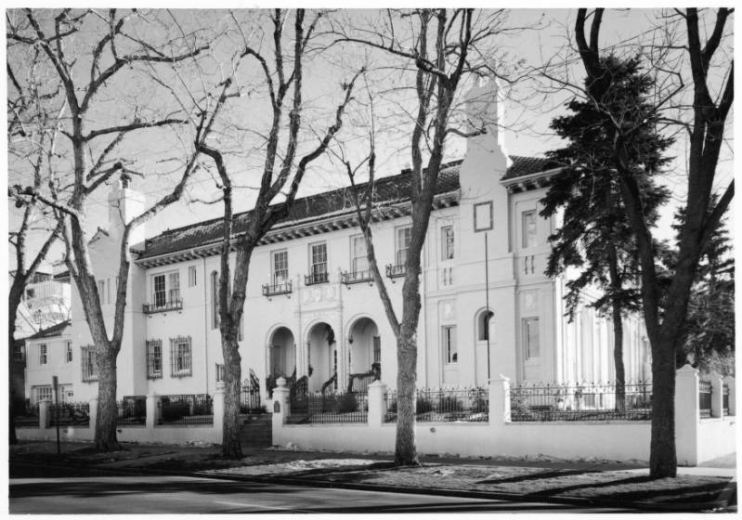 View of the Malo Mansion or House (Harry Manning, Architect, 1921) at 500 East 8th (Eighth) Avenue in the Capitol Hill Neighborhood of Denver, Colorado. The Spanish Colonial Revival residence has a low pitched tile roof, chimneys, wrought iron fences, an arcade at the entry, and an ornate portico.