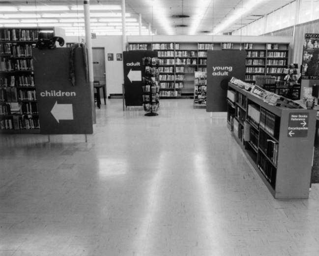 Interior view of the Athmar Park Branch of the Denver Public Library in Denver, Colorado; shows bookshelves and signs: "Children, Adult, Young Adult, New Books, Reference, and Encyclopedias."