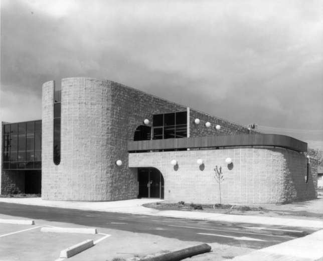 View of the Bear Valley Branch of the Denver Public Library (Anderson, Barker, and Rinker Architects) at 5171 West Dartmouth Avenue in the Harvey Park South neighborhood of Denver, Colorado; features curved walls and design elements.