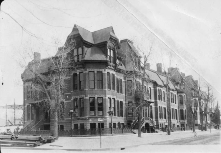 View of Denver Public Library at La Veta Place in Denver, Colorado; shows a brick and stone building with bay windows, garden level sidewalk entries, and a sign: "Public Library." Carnegie Library construction is visible in the background.